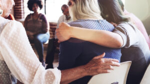 Woman being embraced in group intervention 